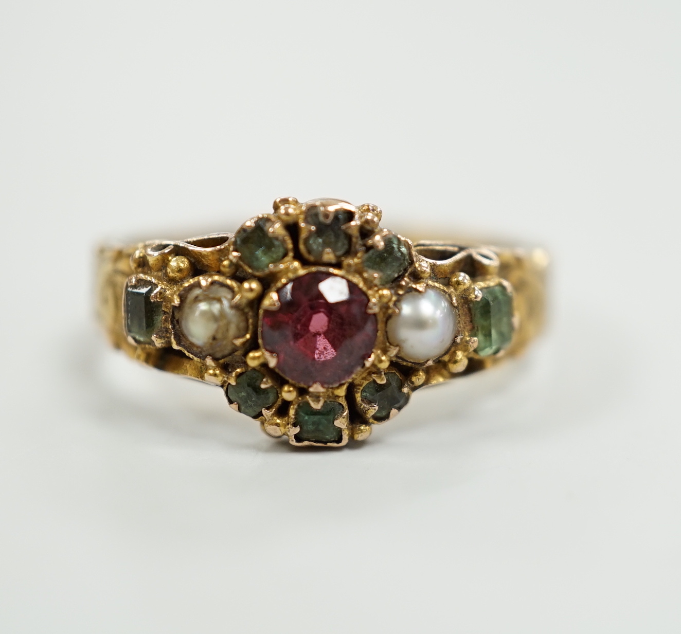 A late Victorian 15ct gold, ruby?, emerald and seed pearl cluster set dress ring, size K, gross weight 2.6 grams, with engraved shank.